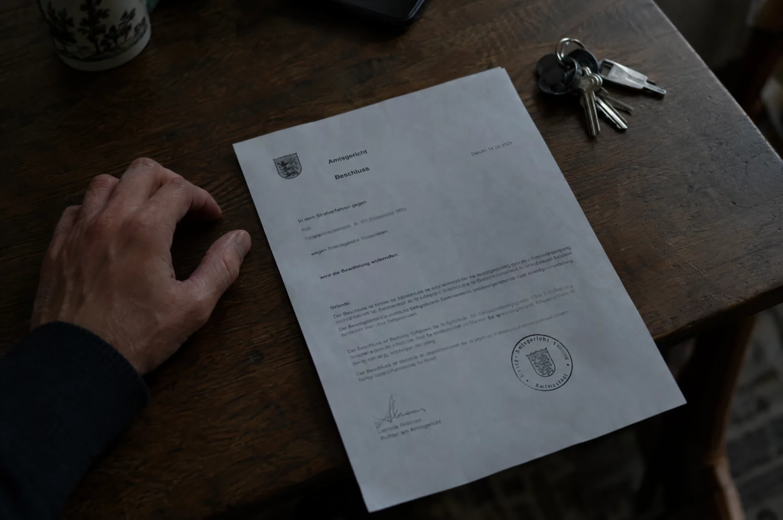 Bewährung Gerichtsbeschluss mit Stempel liegt auf einem Holztisch – bei Verstoß gegen Weisungen droht der Widerruf der Bewährung.