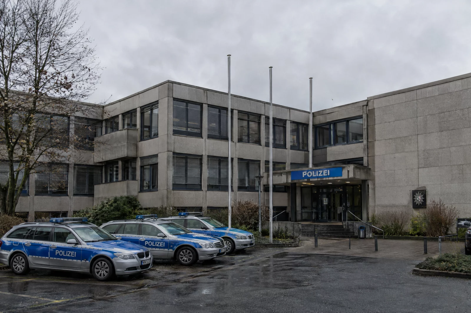 Gebäude einer Polizeidirektion mit Schriftzug POLIZEI und parkenden Streifenwagen, Ausgangspunkt polizeilicher Gefährderansprachen.