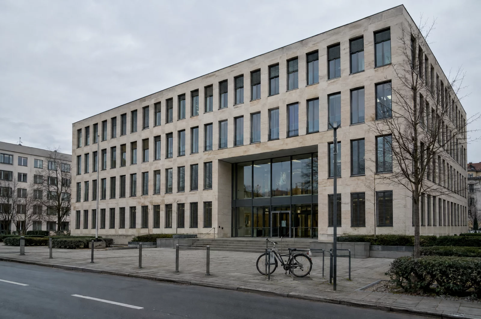 Sachliches Justizgebäude der Staatsanwaltschaft bei bedecktem Himmel, wo über eine Anklage wegen § 184a StGB entschieden wird.