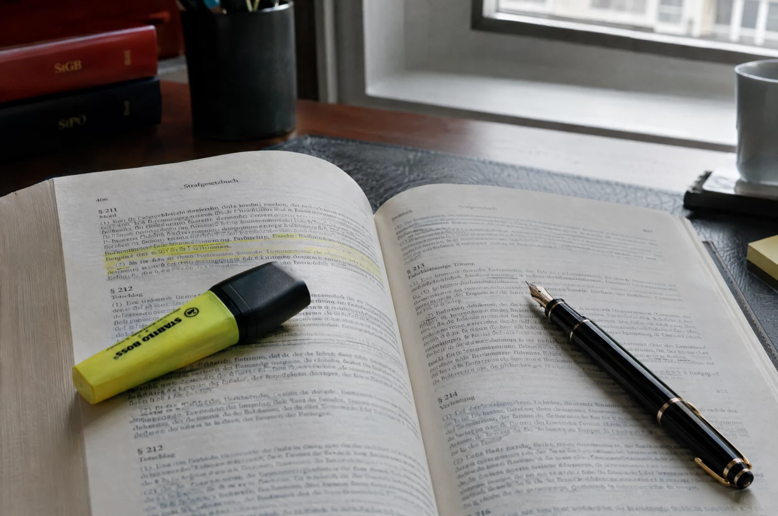 Aufgeschlagenes Strafgesetzbuch mit Textmarker auf dem Schreibtisch eines Anwalts zur Prüfung des Tatbestands nach § 184a StGB.