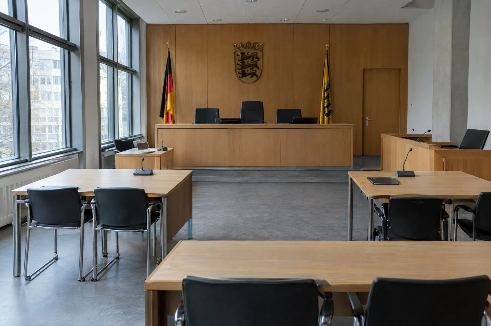 Leerer Sitzungssaal eines Jugendgerichts mit Richterbank und eigenem Tisch für die Jugendgerichtshilfe im Strafverfahren.