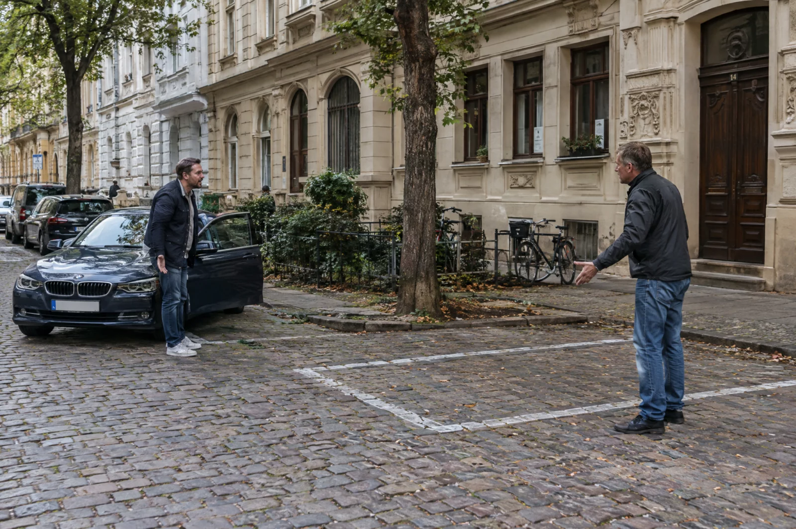 Zwei Männer streiten auf einer Kopfsteinpflasterstraße um eine Parklücke – eine Situation, aus der ein Nötigungsvorwurf entstehen kann.