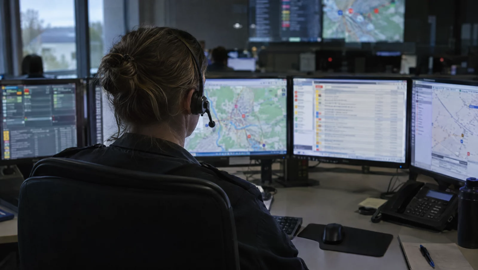 Ein Disponent mit Headset arbeitet in der Rettungsleitstelle an mehreren Bildschirmen – jeder missbräuchliche Notruf bindet Kräfte.