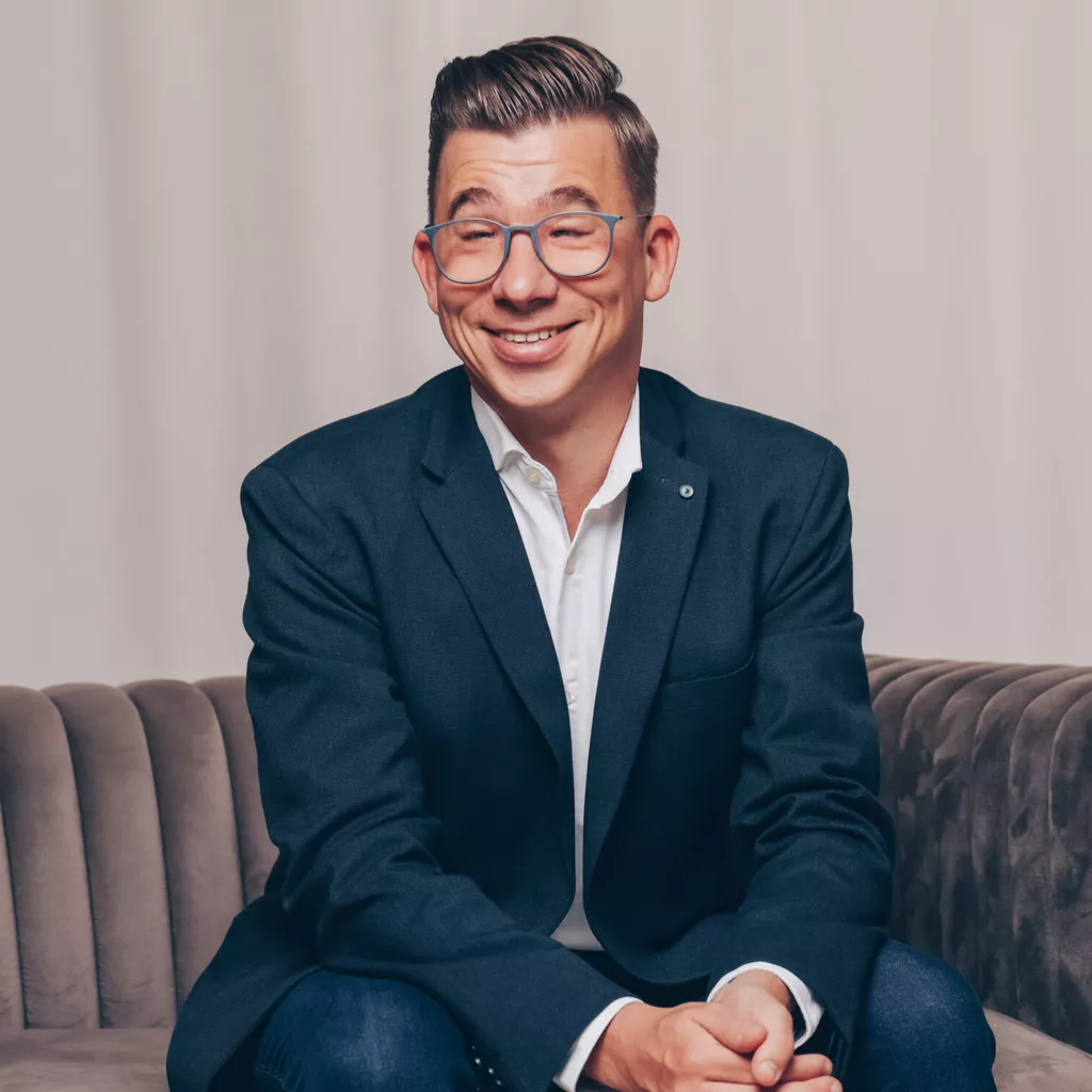 Rechtsanwalt Tommy Kujus sitzend auf einem Sofa