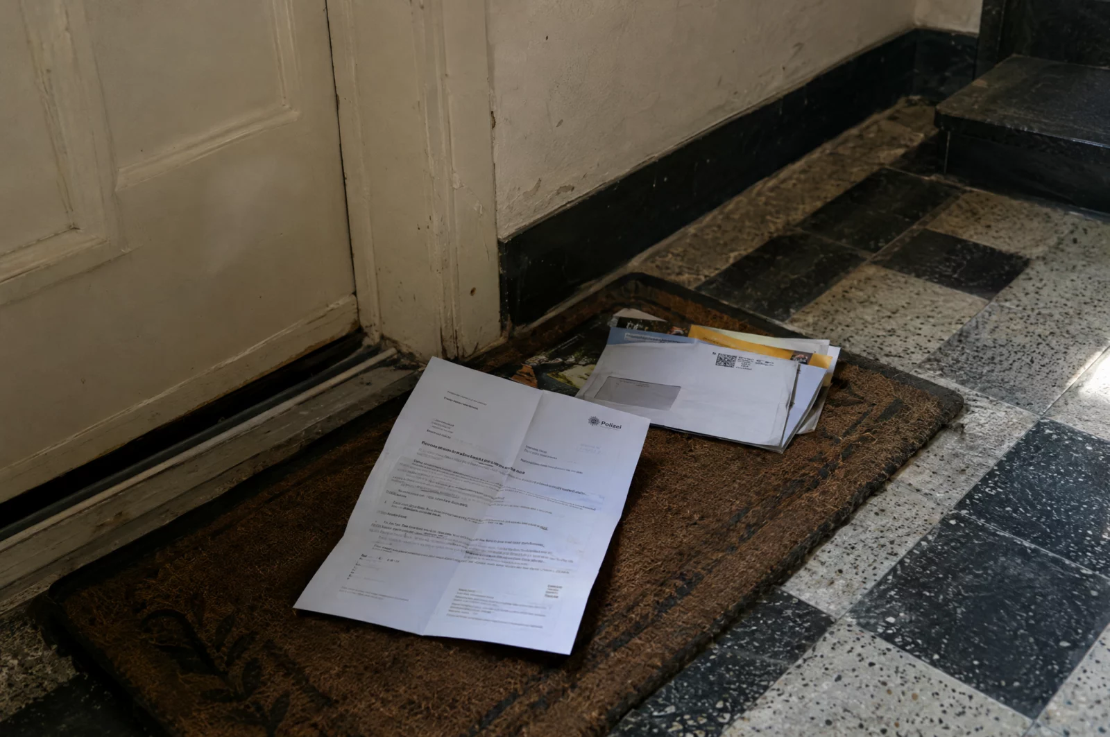 Geöffnete Vorladung zur Beschuldigtenvernehmung liegt im Flur einer Altbauwohnung, der Vorwurf betrifft eine lange zurückliegende Tat.